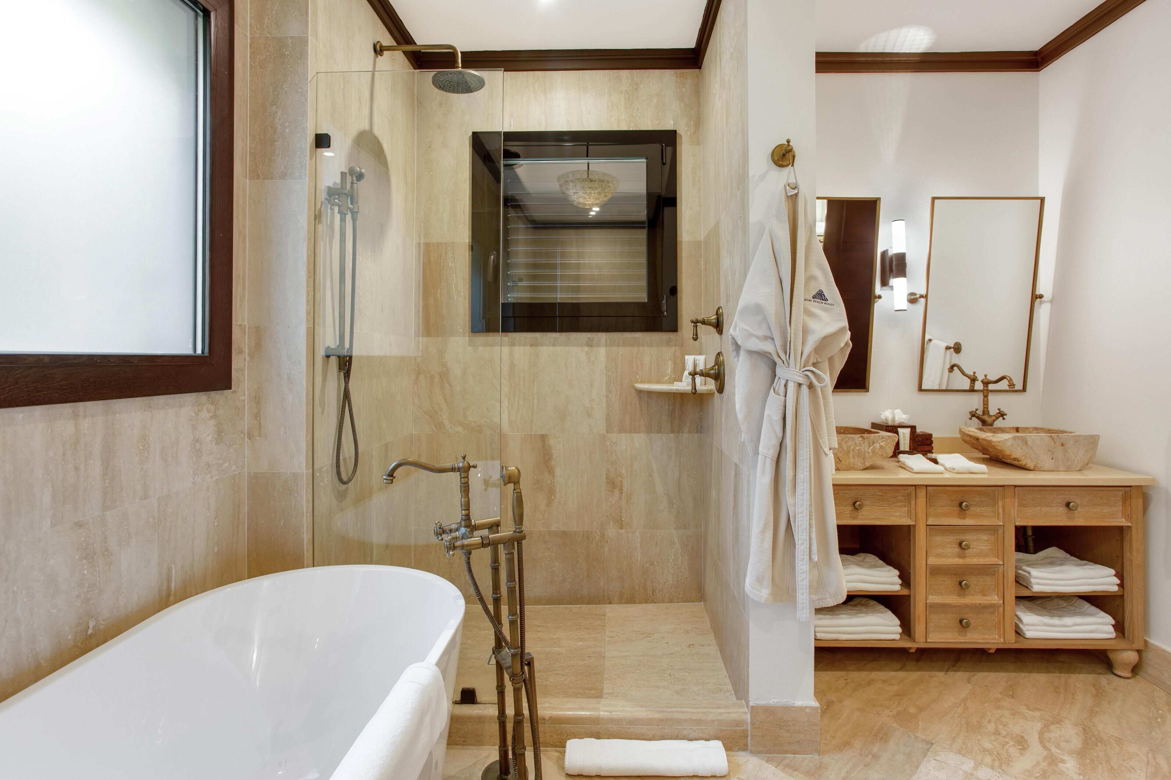 A modern bathroom with a freestanding bathtub, a walk-in shower, and a vanity with a large mirror.
