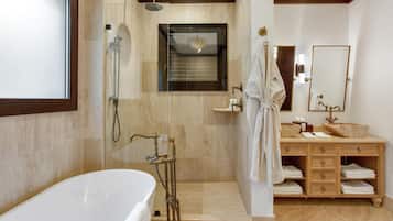 A modern bathroom with a freestanding bathtub, a walk-in shower, and a vanity with a large mirror.