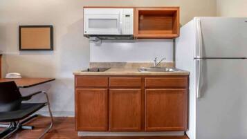 A compact kitchen with a microwave, sink, and refrigerator.