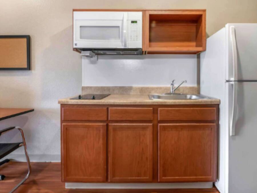 A compact kitchen with a microwave, sink, and refrigerator.