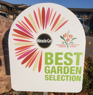 A sign with the text "Miracle-Gro Best Garden Selection" and a logo with a sunburst design.