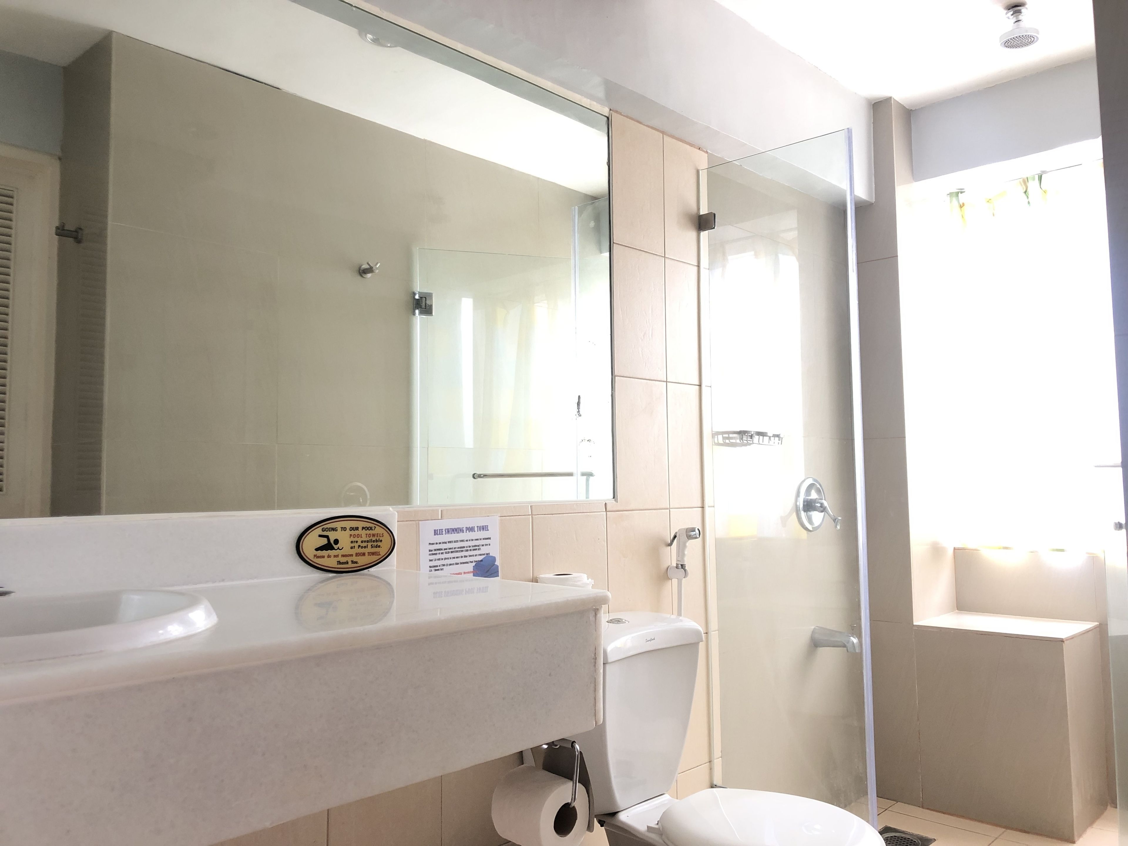 Um banheiro moderno com box de vidro, pia branca e vaso sanitário.