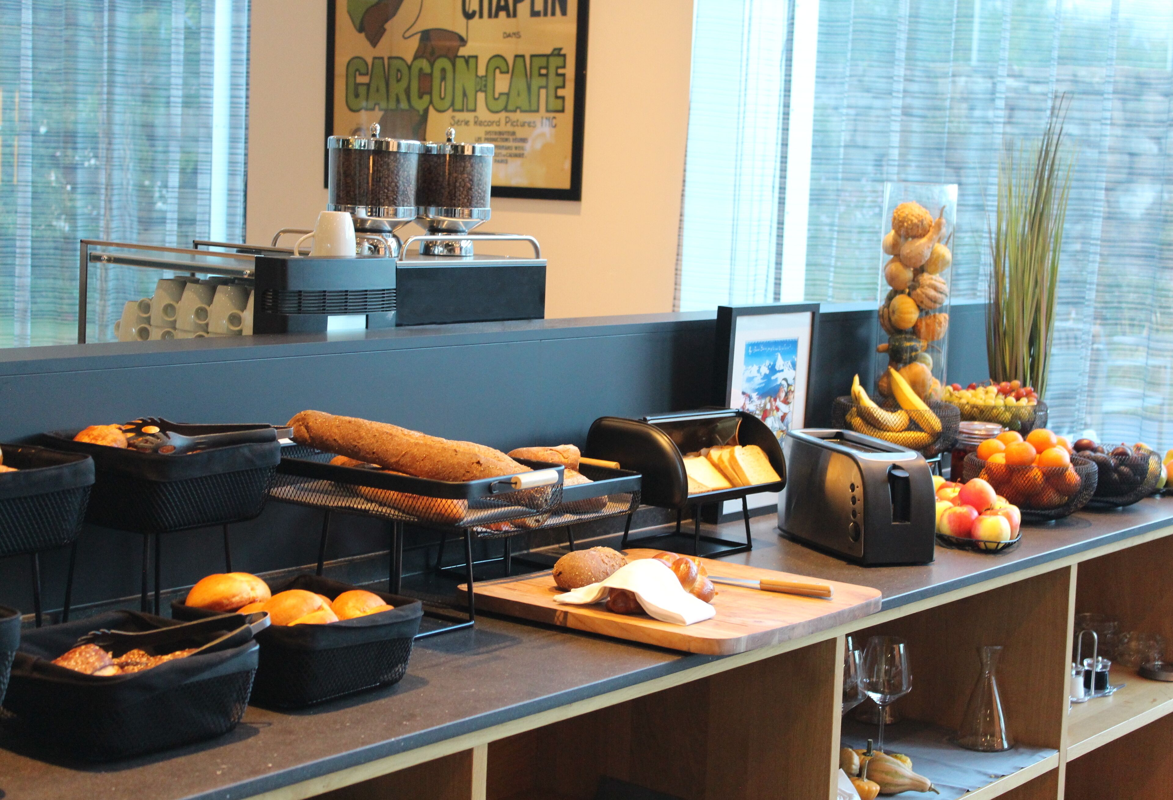 Um buffet de café da manhã com diversas opções de comida e uma máquina de café.