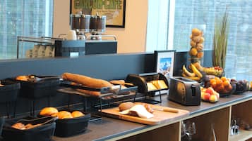 Um buffet de café da manhã com diversas opções de comida e uma máquina de café.