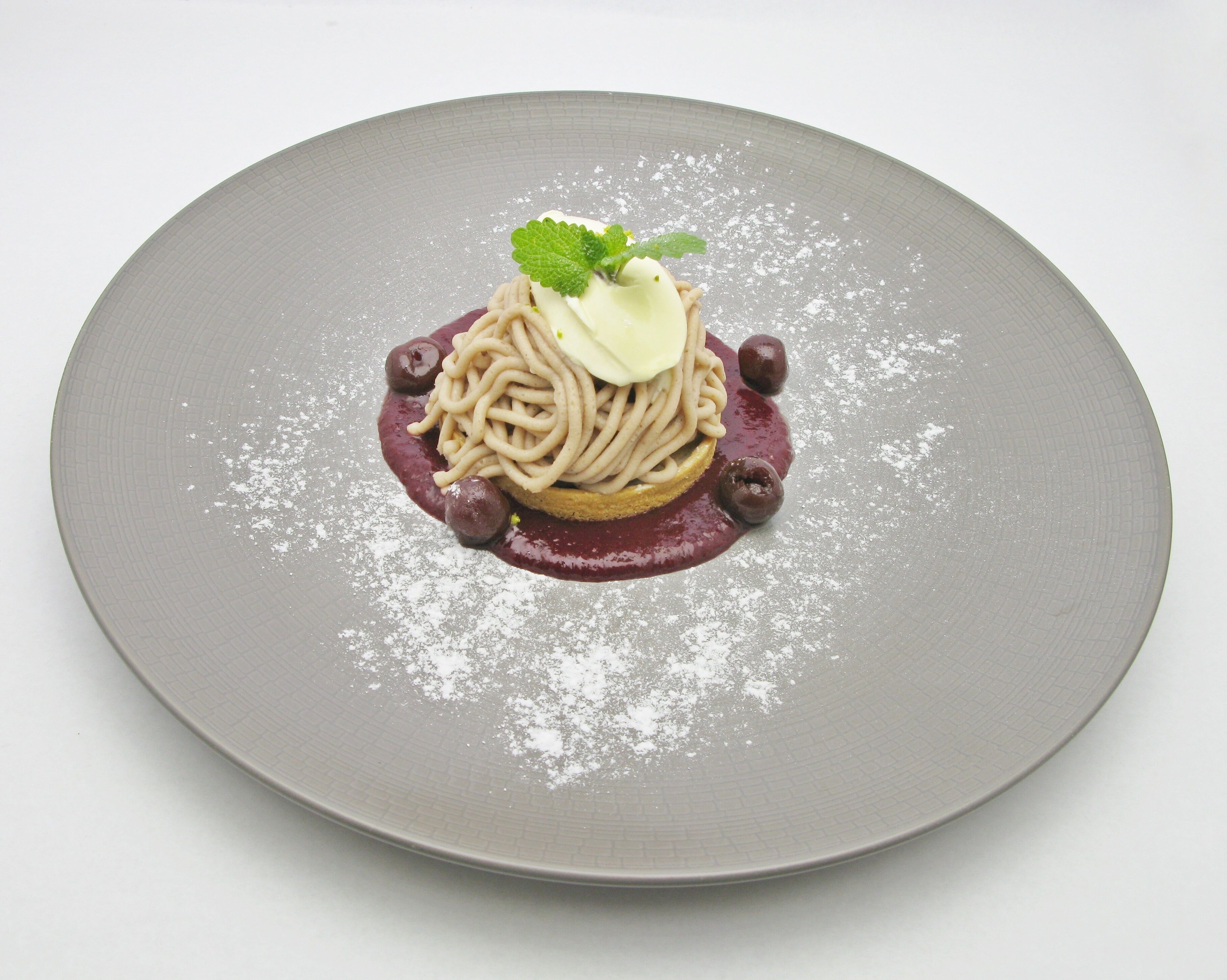 A dessert on a plate with a textured grey surface.