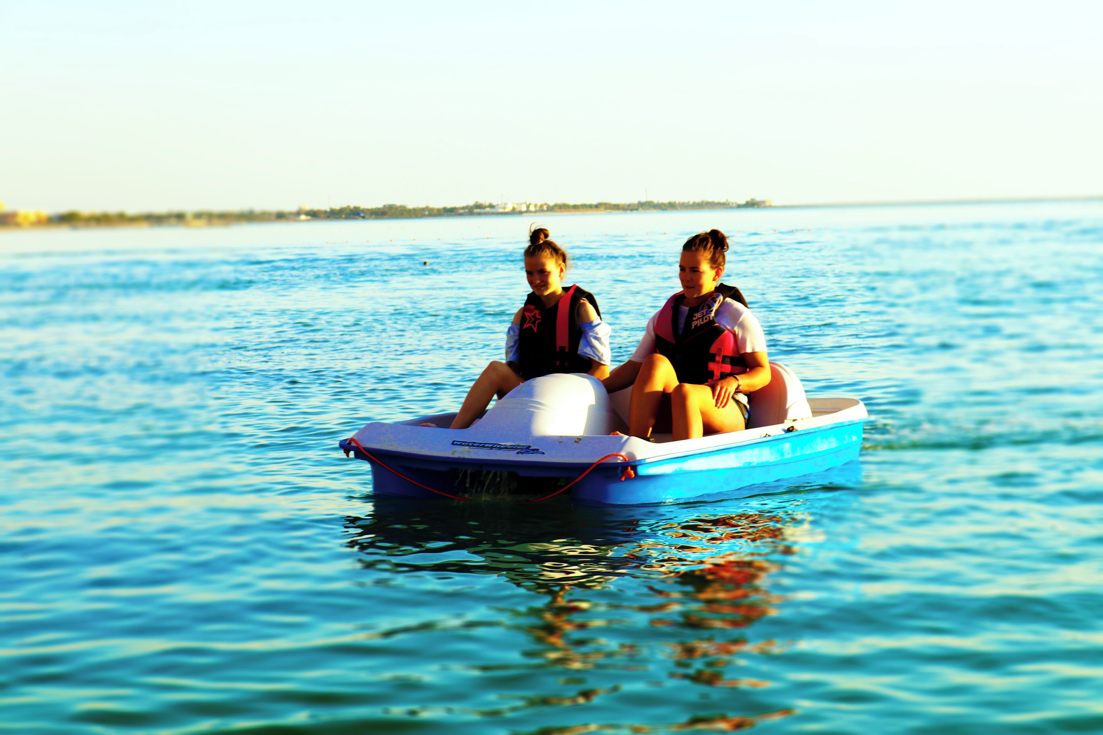Two people in a small blue boat on a body of water.