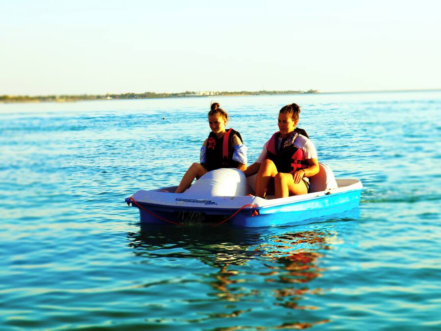 Two people in a small blue boat on a body of water.