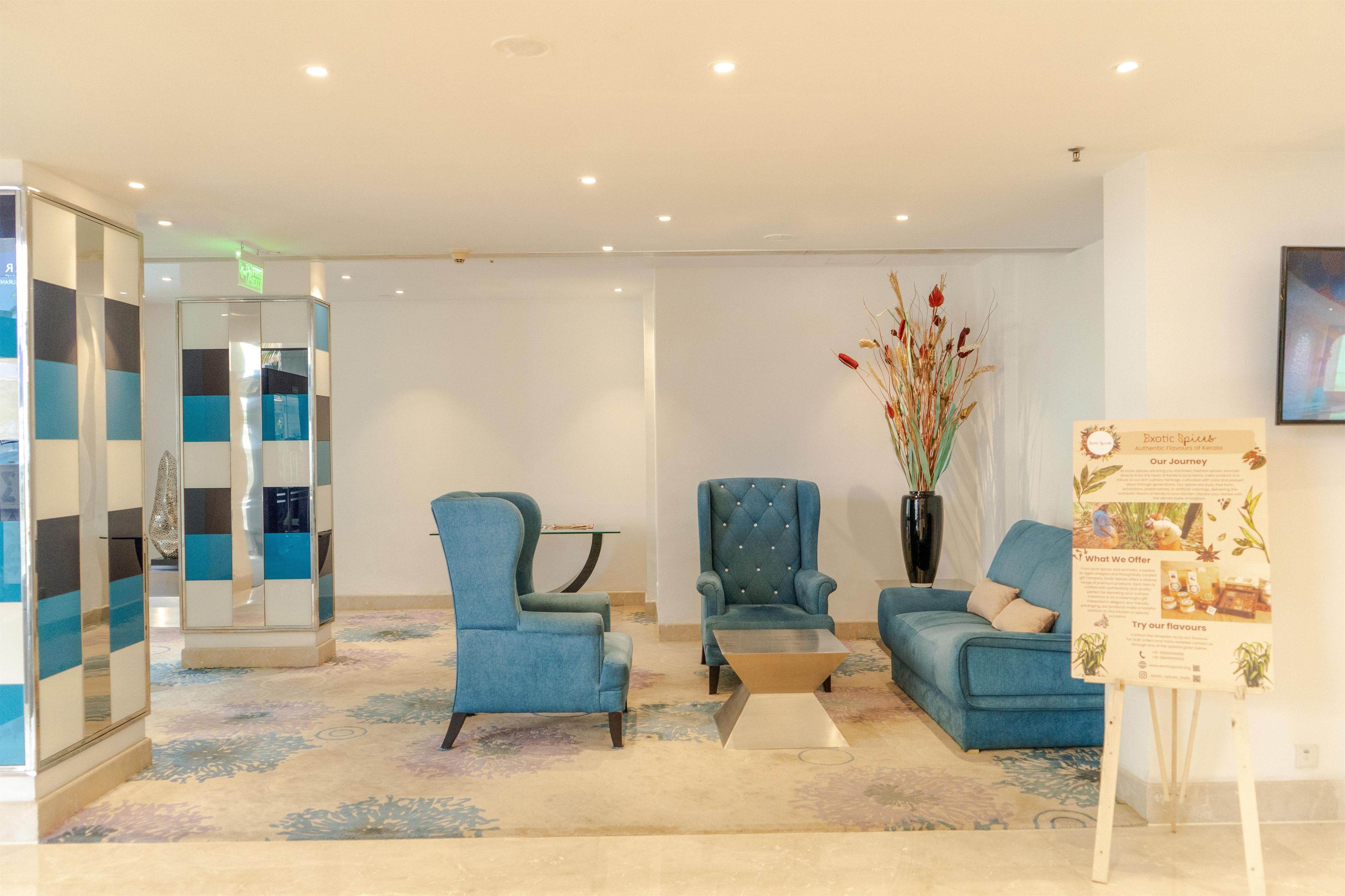A reception area with a seating arrangement, a decorative vase, and informational signage.