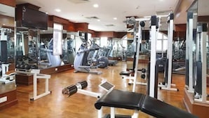 A gym with various exercise equipment, including treadmills, weight machines, and free weights. - Radisson Blu Kochi (Kanayannur)