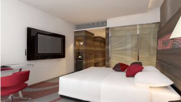 Una habitación de hotel moderna con una cama grande, un televisor montado en la pared y una silla roja.