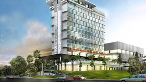 Un hôtel moderne doté d  ’une façade en verre, de plusieurs étages et d’un toit plat agrémenté de verdure.