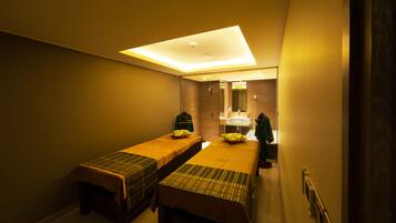 Two single beds with matching headboards and footboards, set against a clean, neutral backdrop.