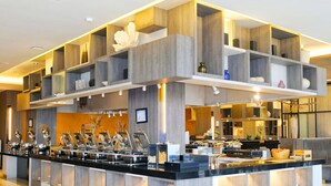 Un buffet moderne, doté de plusieurs points de service et d’un espace central dédié à la préparation des plats.