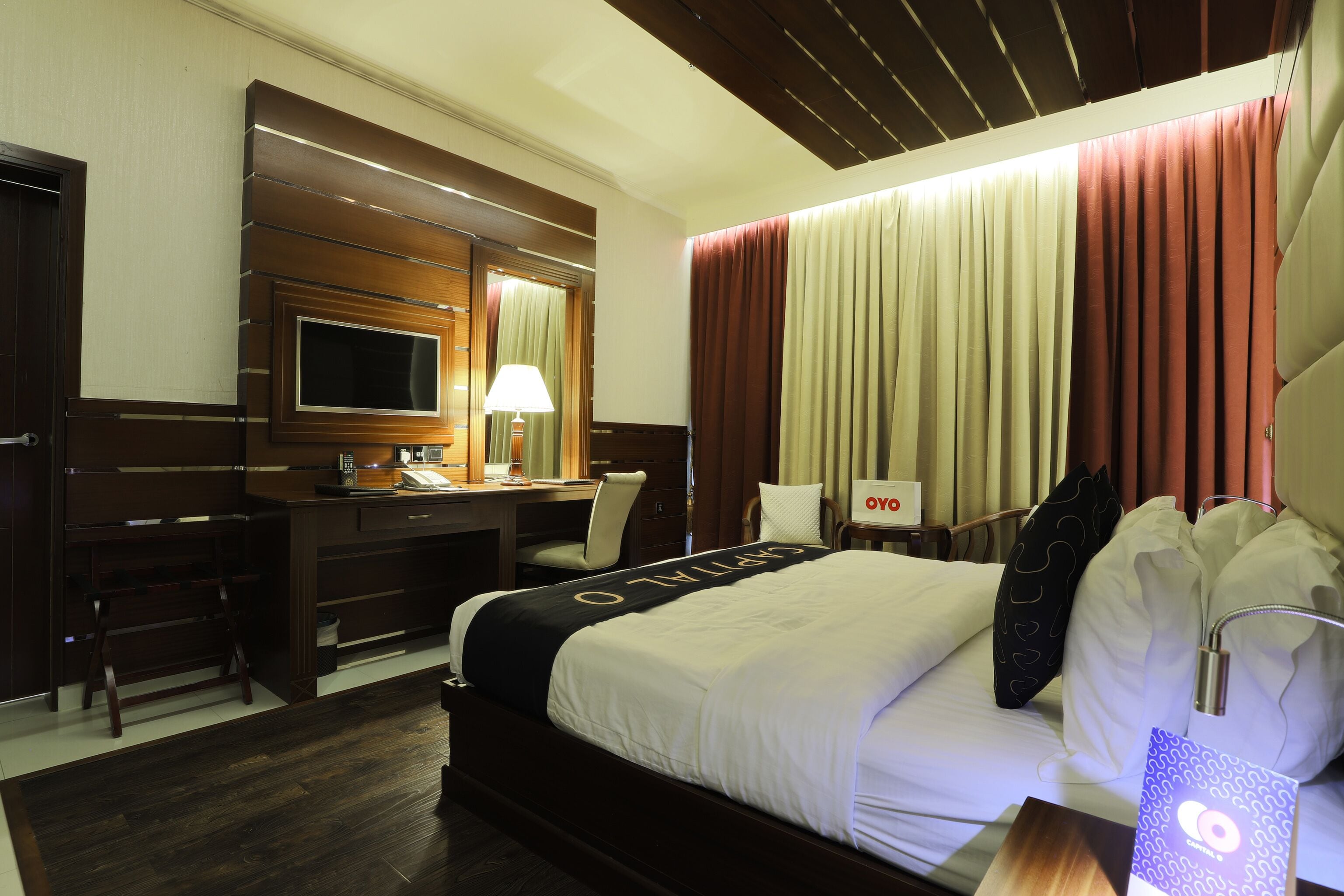 Een hotelkamer met een bed, bureau, stoel en een televisie.