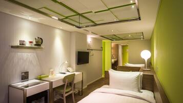 Een hotelkamer met een bed, bureau, stoel en een televisie.