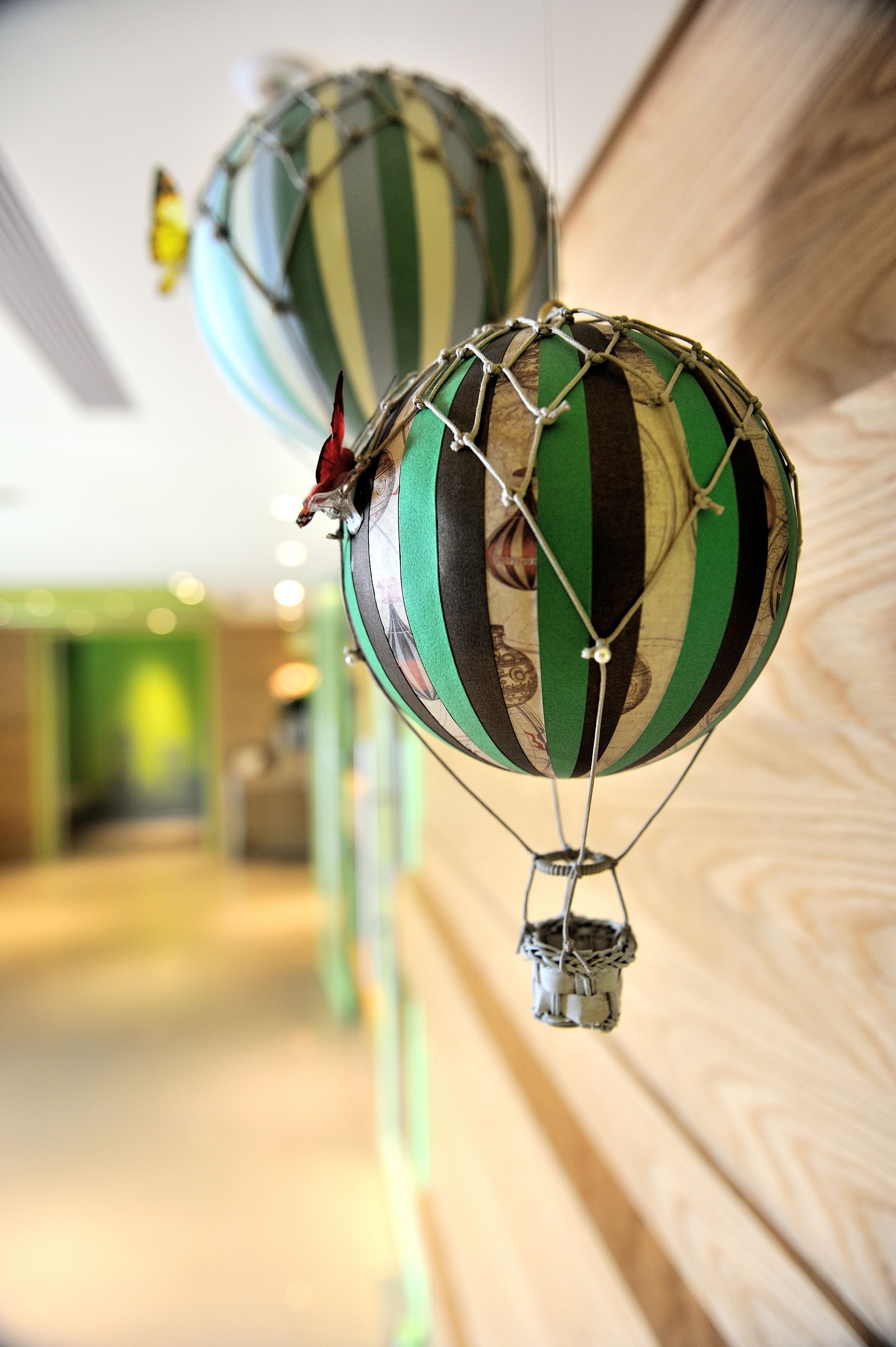 Two hot air balloons with a striped pattern, suspended by wires.
