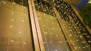 A building facade with string lights hanging across the windows. - Beluga Guest House - Hostel (Yeosu)