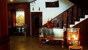 Un escalier orné de boiseries sculptées, une vitrine et un autel décoratif agrémenté de bougies.