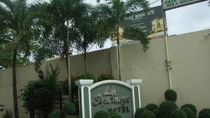La Iberanza Hotels facade med et skilt, en låge og en motorcykel parkeret i nærheden.