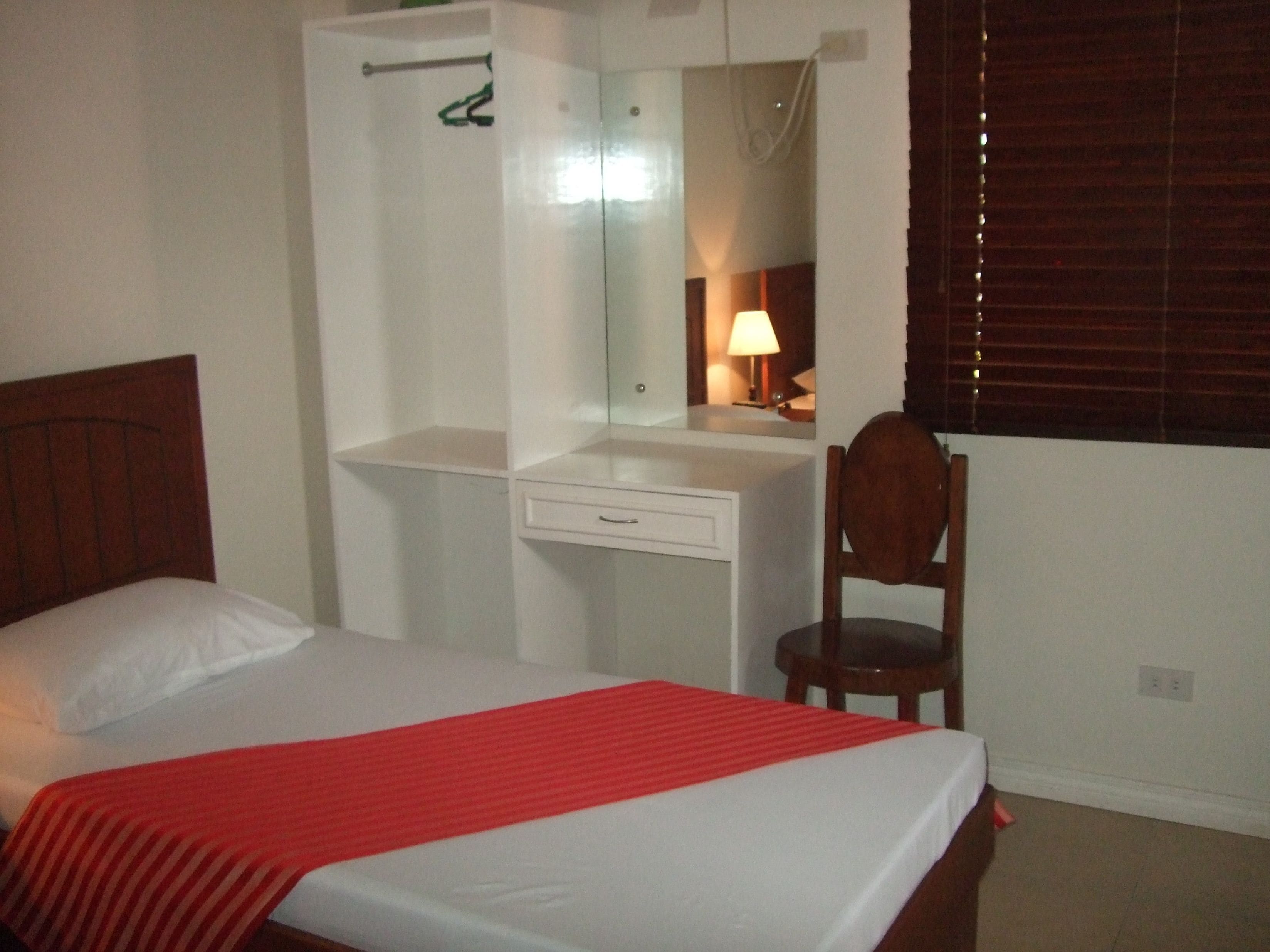 Un dormitorio con cama, escritorio y silla.