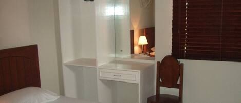 Un dormitorio con cama, escritorio y silla.