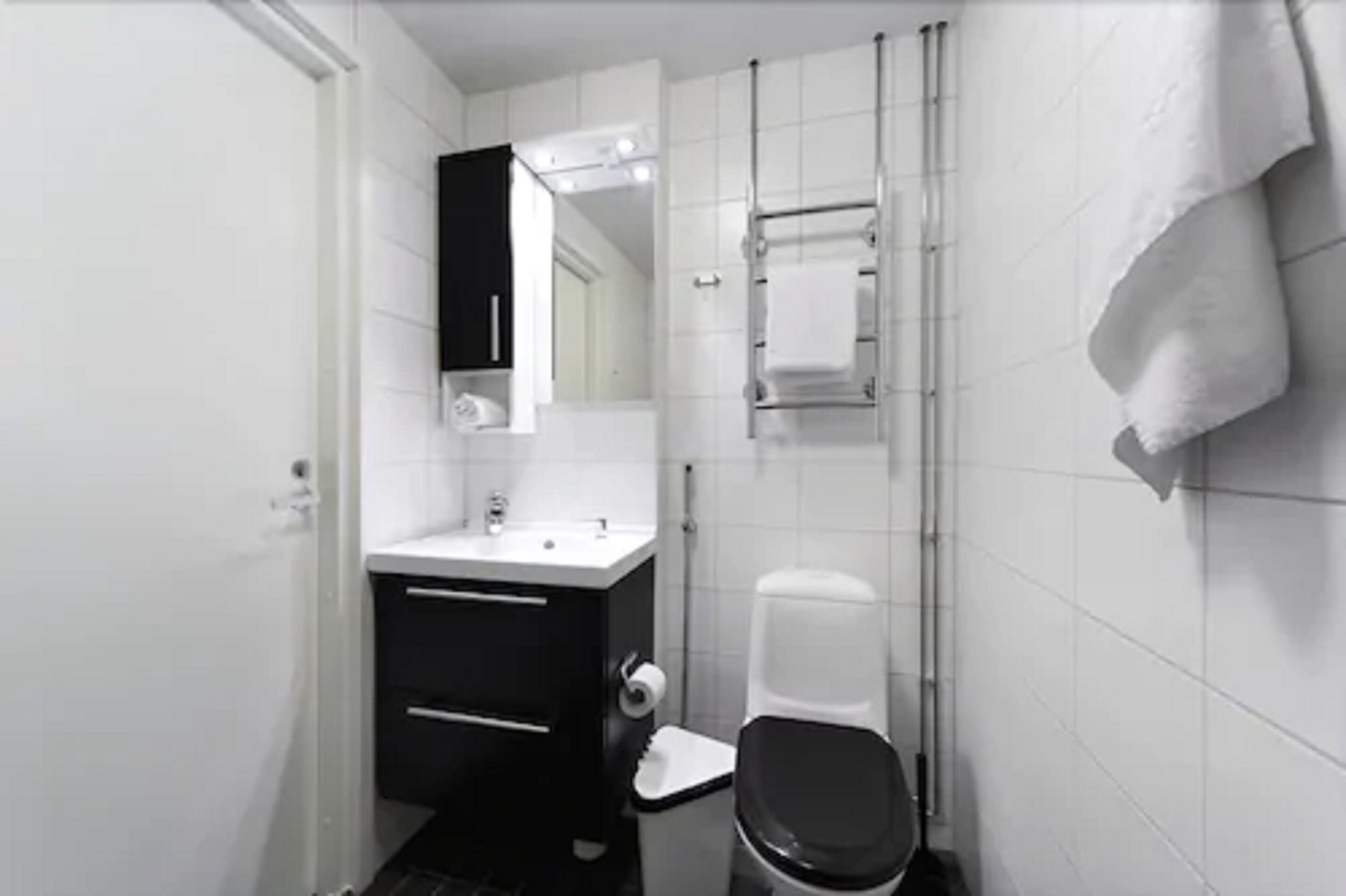 A compact bathroom with a toilet, sink, and mirror.