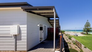 A building with a covered outdoor area, a visible door, and a clear view of the ocean.