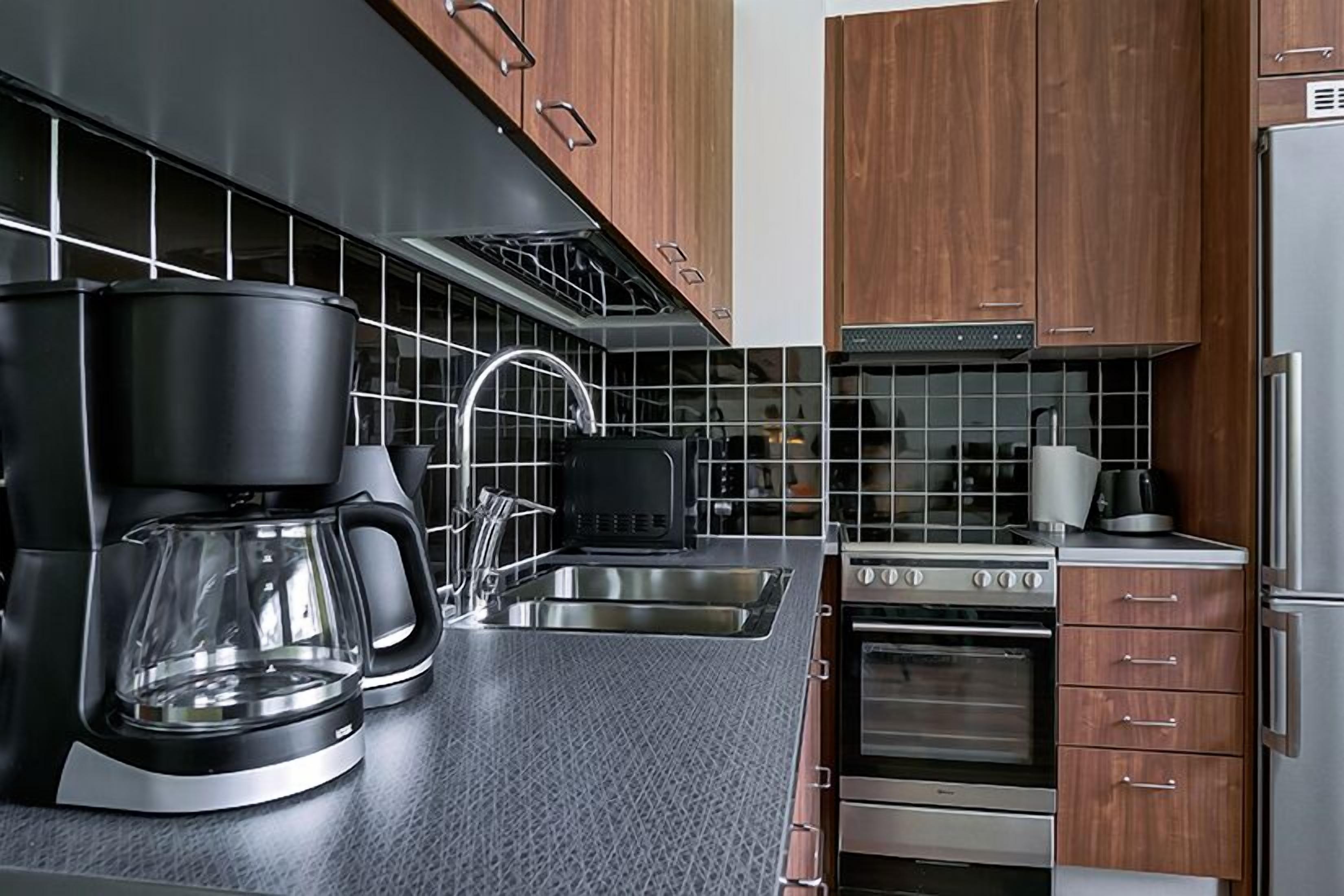 A modern kitchen with a coffee maker, toaster, and oven.