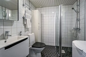 A modern bathroom with a white sink, toilet, and shower.