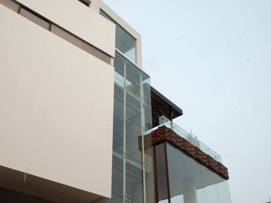A modern building with a glass facade and a wooden slatted roof.