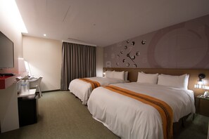 A hotel room with two beds, a desk with a chair, a TV, and a clock on the wall. - Travel Art Inn (Chiayi City)