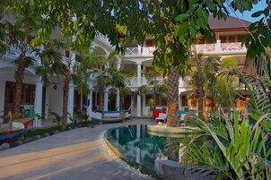 Un resort con piscina, palmeras y un bote.