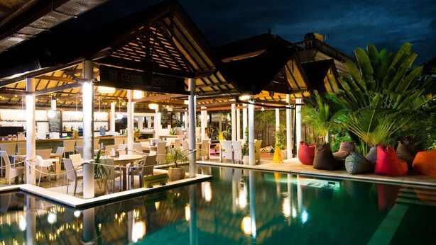 An indoor pool area with a covered seating area and a restaurant named "The Colonial Restaurant." - OK Divers Resort & Spa (Padangbai)