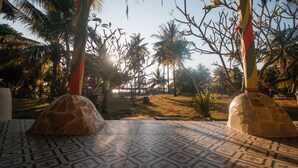 Un piso de baldosas con diseños, palmeras y una estructura de piedra en un entorno tropical.