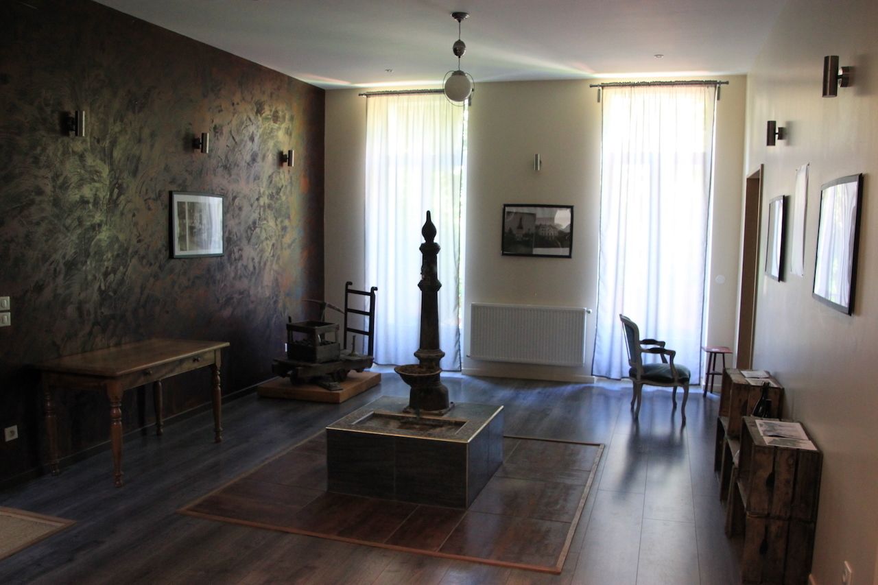 A room with a fireplace, wooden furniture, and artwork on the walls.