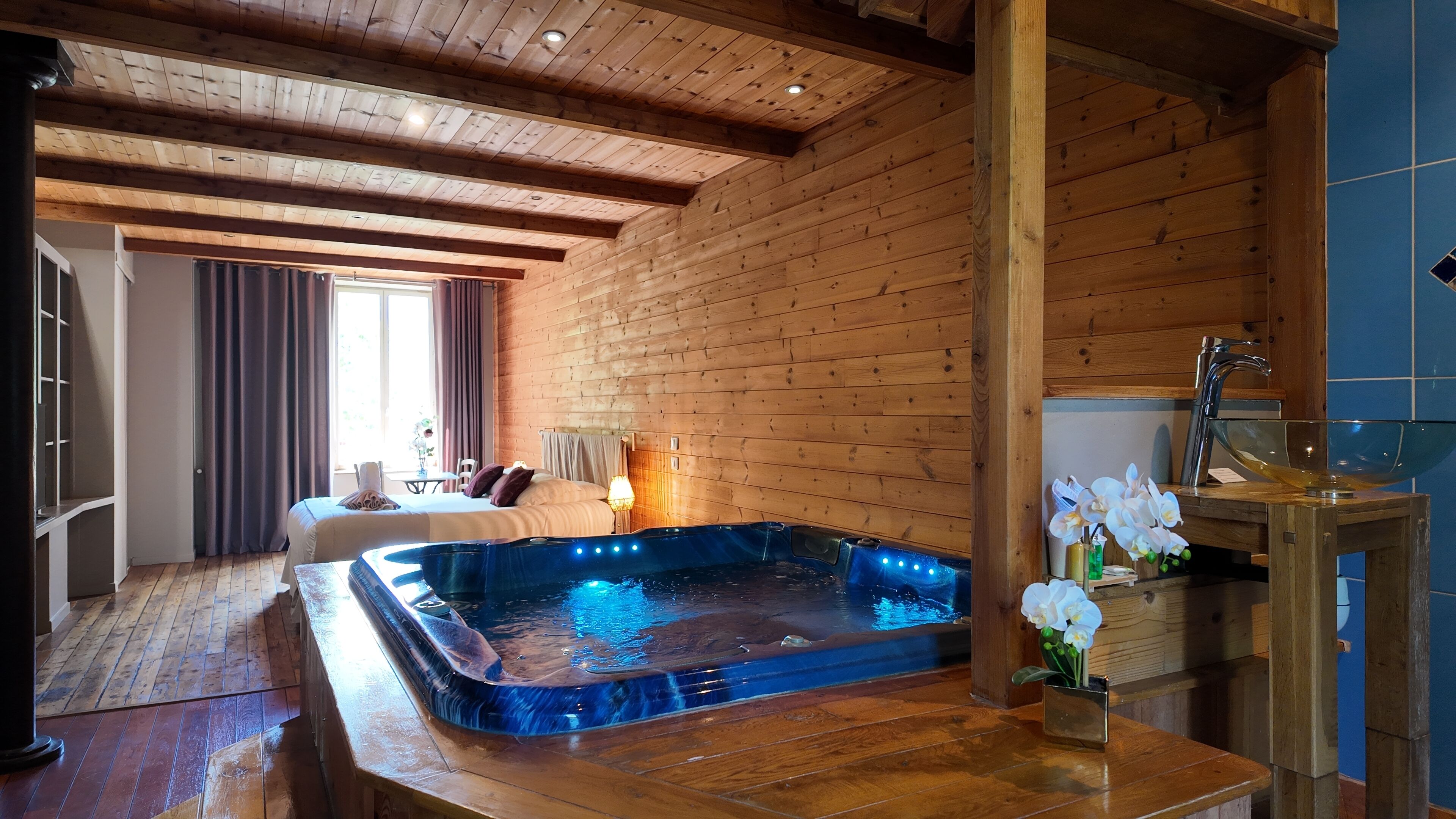 A wooden interior with a hot tub, a dining area, and a view of the outdoors.