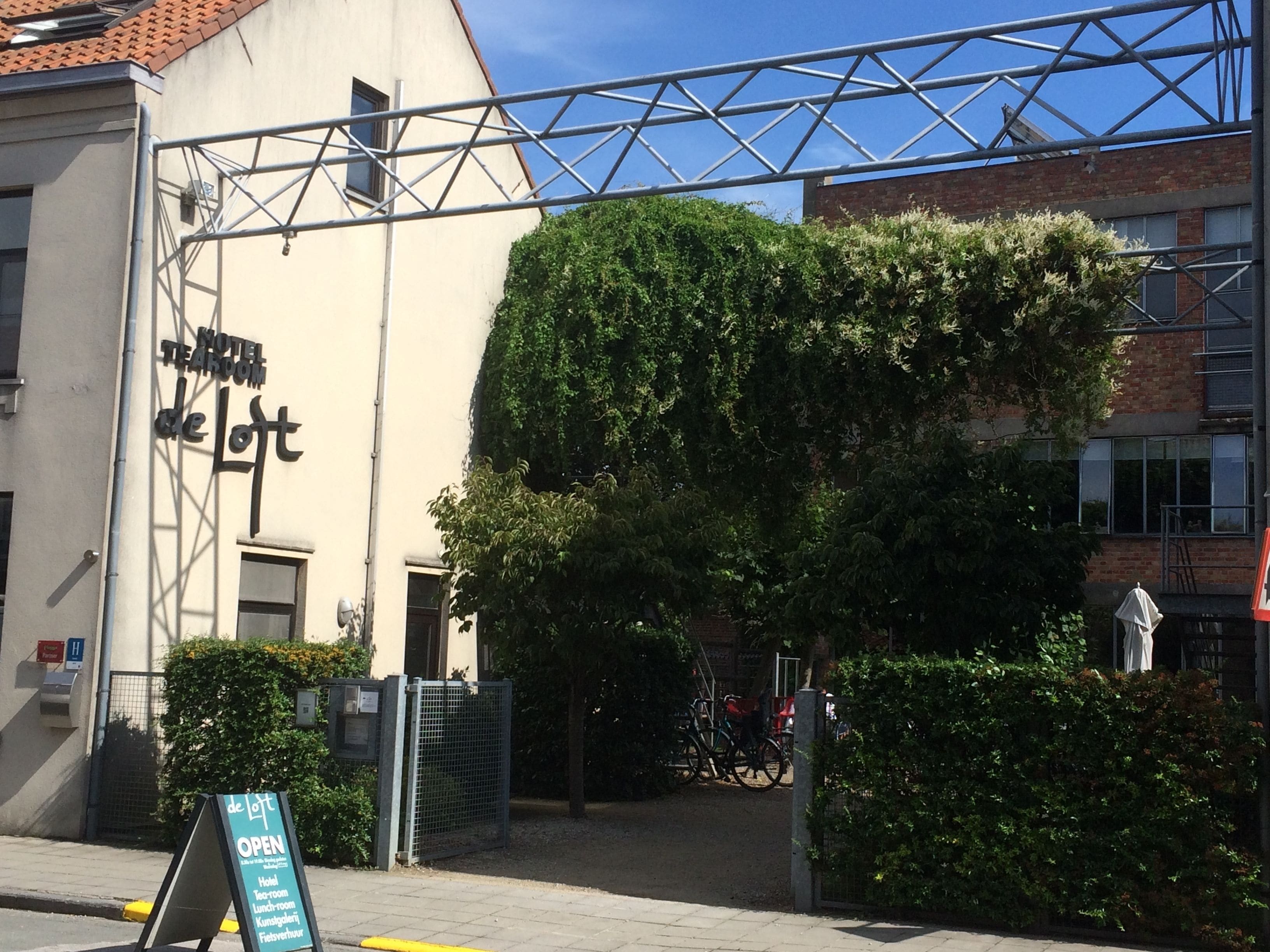 A hotel named "Hotel de Loft" with a signboard indicating it's open.