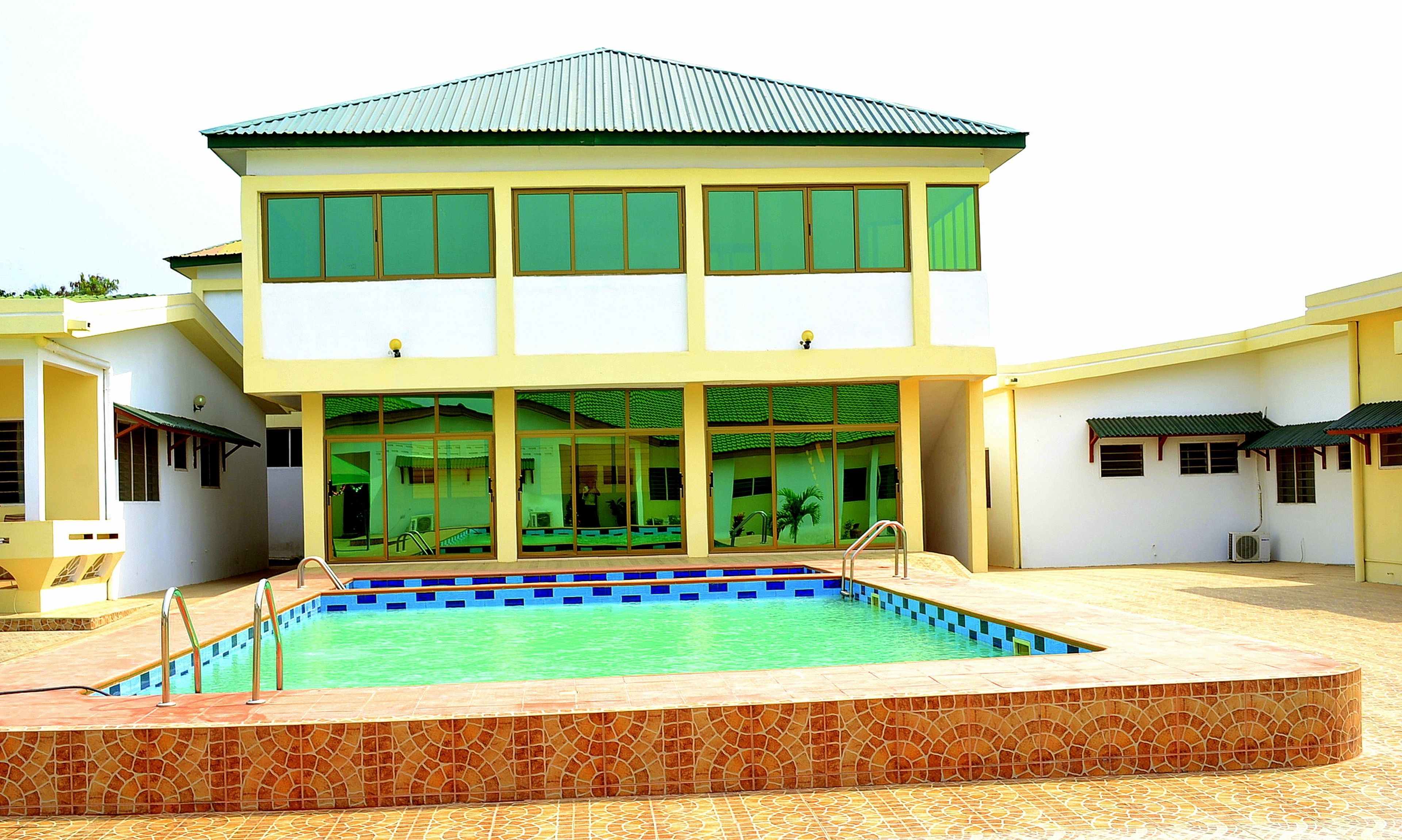 A two-story building with a swimming pool in front.