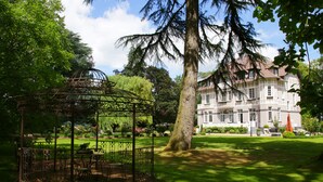 A gazebo in a lush garden with a large building in the background. - Le Château - Fresnoy en Gohelle (Fresnoy-en-Gohelle)
