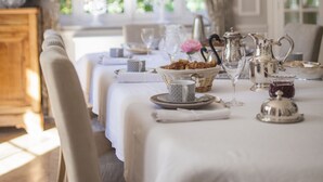 A dining table set with silverware, plates, and a pitcher, with a view of greenery outside. - Le Château - Fresnoy en Gohelle (Fresnoy-en-Gohelle)