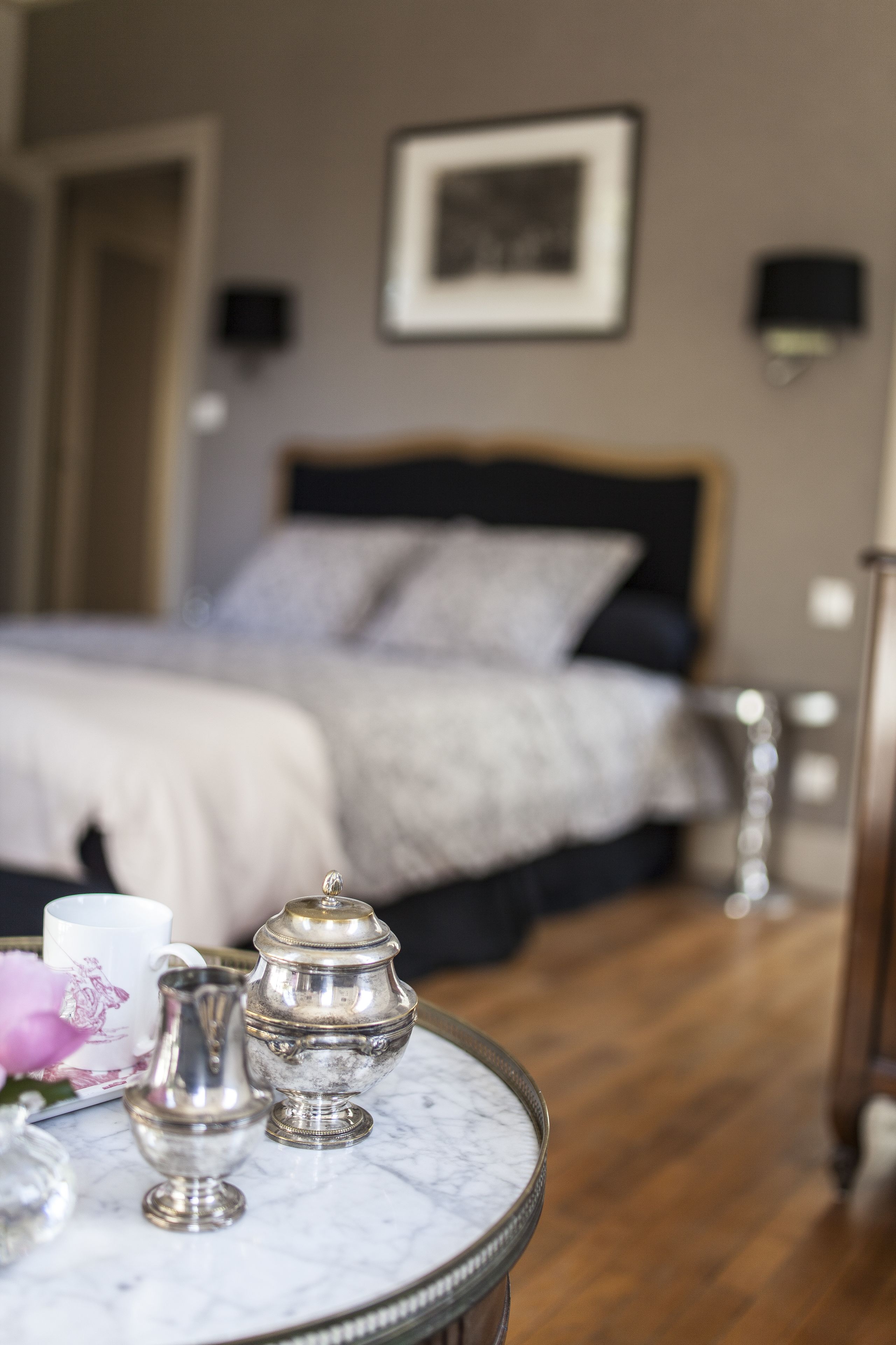 Une chambre à coucher avec un lit, une table de chevet et un tableau encadré au mur.