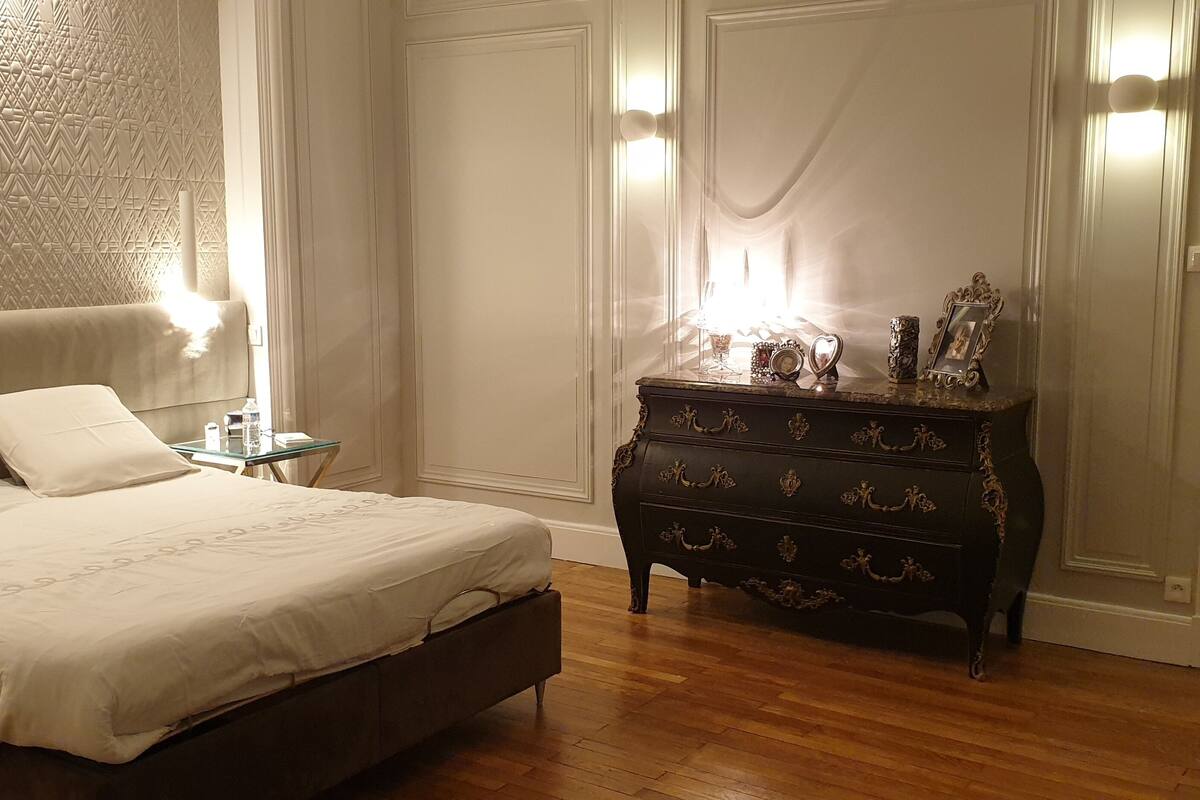 A bedroom with a bed, dresser, nightstand, and a mirror.