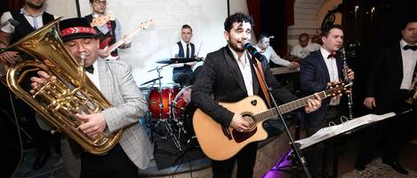 A band performing on a stage with a microphone stand and musical instruments.