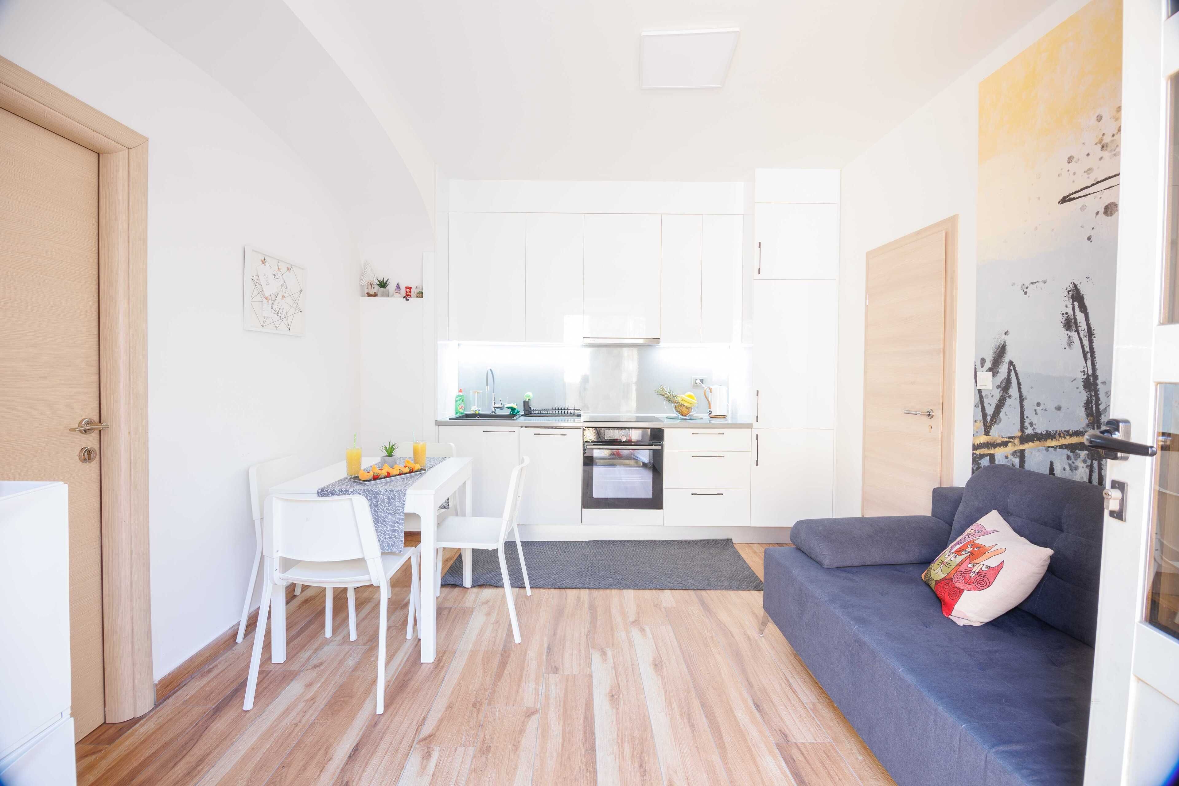 Un espacio habitable compacto con kitchenette, comedor y zona de estar.
