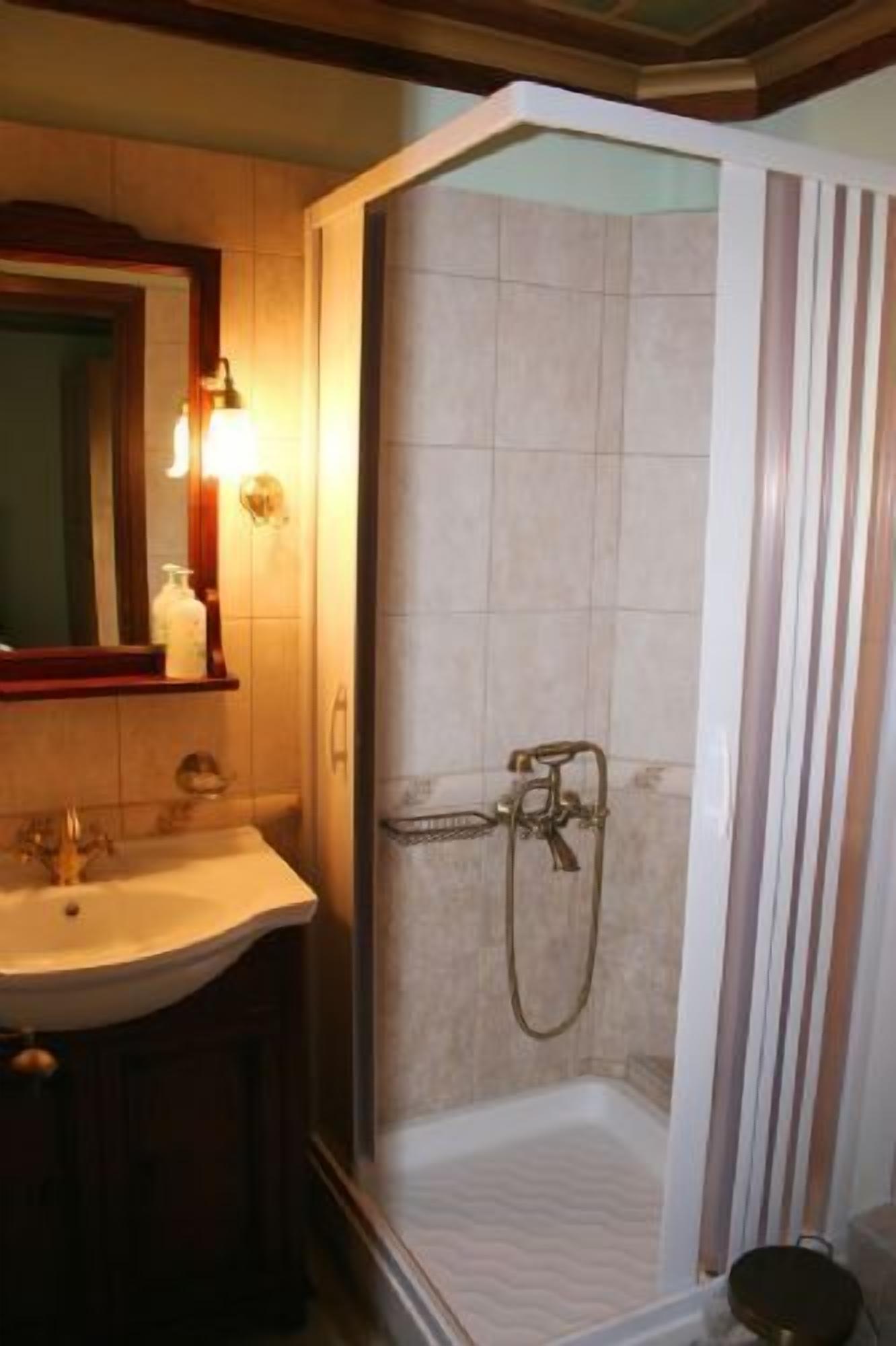 A bathroom with a shower, sink, and mirror.