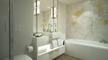 Un baño moderno con inodoro, lavamanos y bañera.