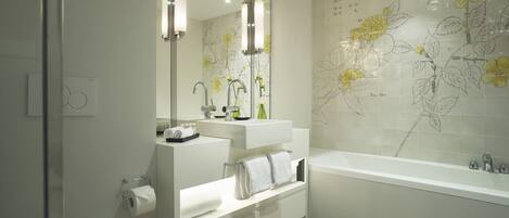A modern bathroom with a toilet, sink, and bathtub.