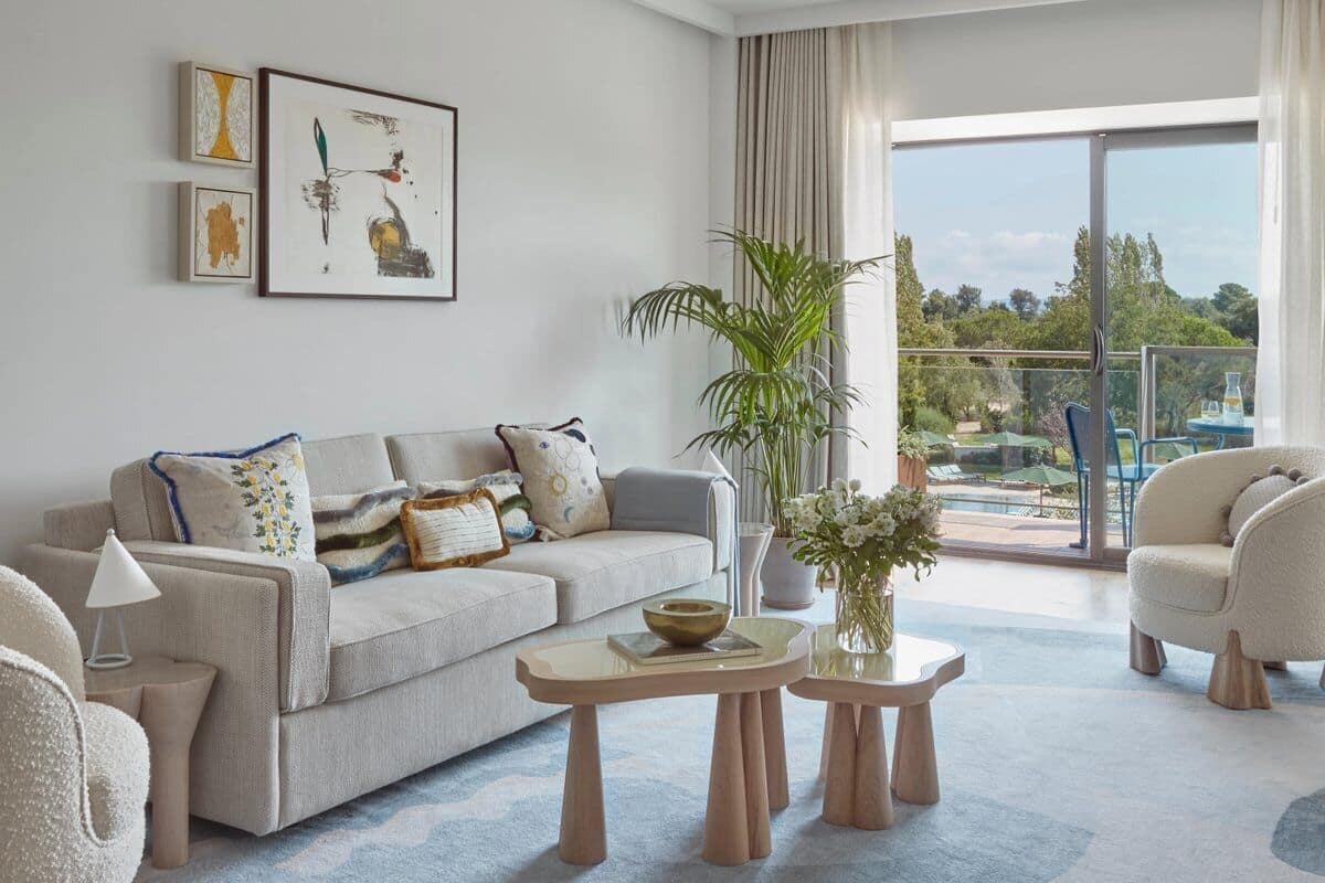 Un salon moderne avec un canapé, deux tables d’appoint et une vue sur l’extérieur.
