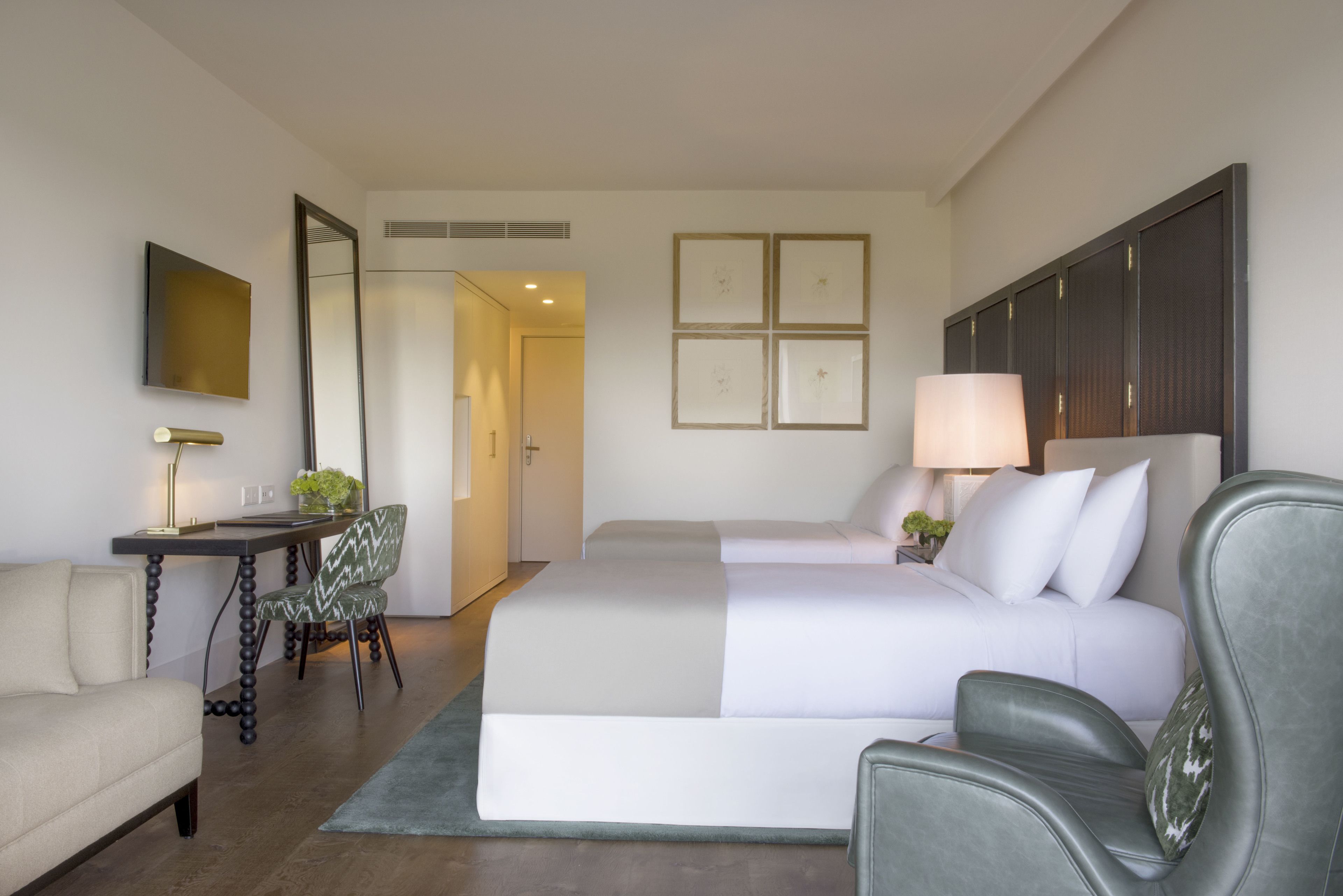 Une chambre d’hôtel avec un lit, un bureau, une chaise et un canapé.