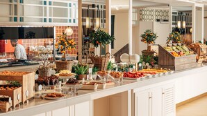 A buffet with various food items, a chef preparing food, and a modern interior design. - Hotel Camiral - The Leading Hotels of the World (Caldes de Malavella)